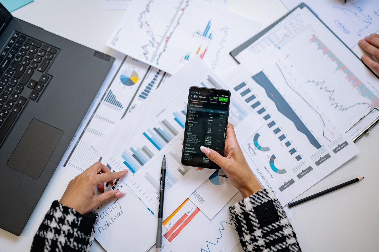 A top-down view of charts and a smartphone in an office, highlighting data analytics.